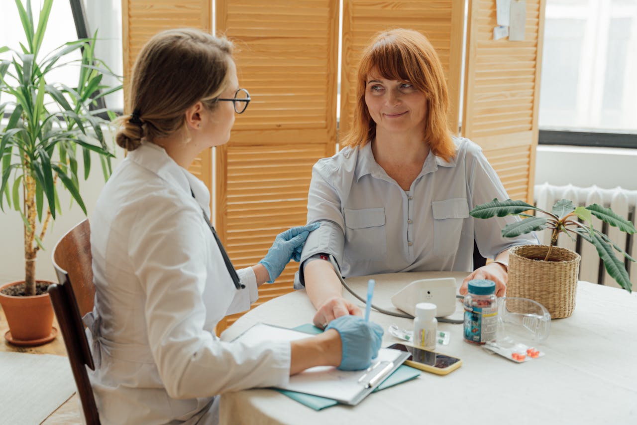 Doctor measuring patients blood pressure with digital monitor in a clinical setting.